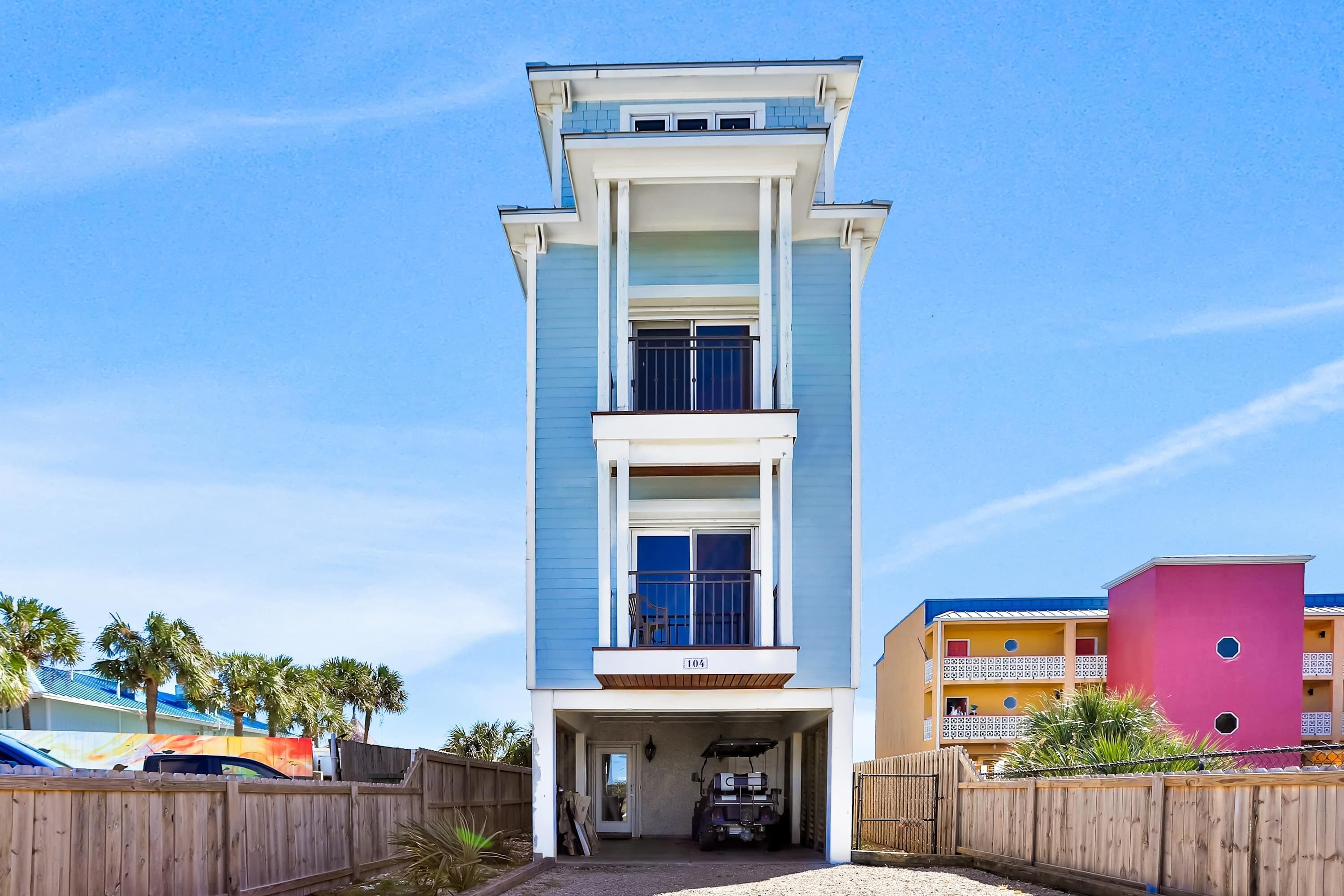 A two-story building with a garage entrance, a balcony on the second floor, and a visible number "104".