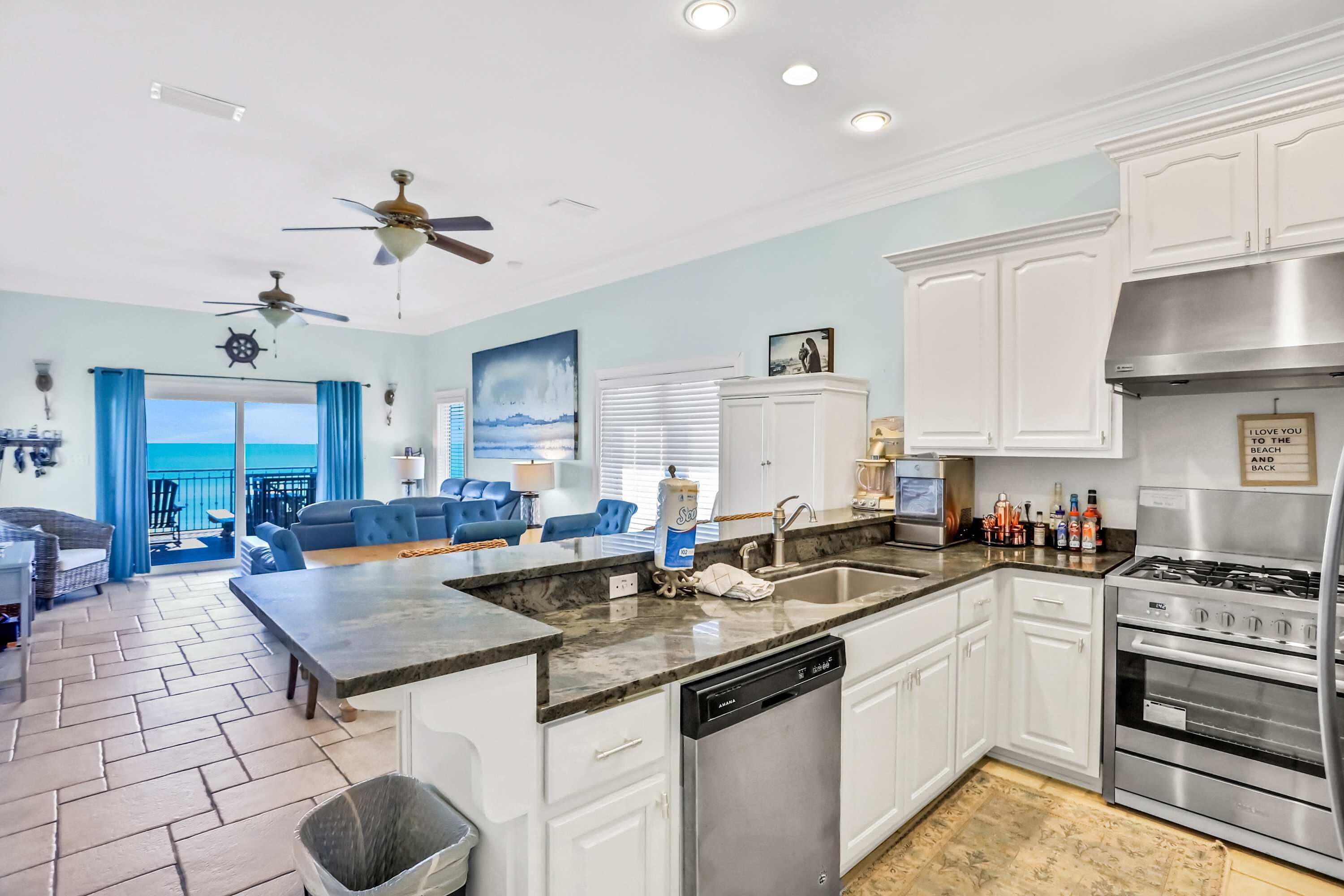 A modern kitchen with white cabinets, a stainless steel stove, and a dishwasher.