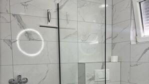 A modern bathroom with a glass shower enclosure, a toilet, and a small trash bin. - Apartment Lavaran 3 in Vir (Vir)