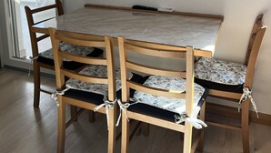 A dining area with a wooden table and chairs, a mirror on the wall, and a sliding glass door leading outside. - Apartment Lavaran 3 in Vir (Vir)