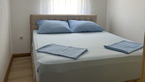 A bedroom with a bed, a window with sheer curtains, and a light-colored wall. - Apartment Lavaran 4 in Vir (Vir)