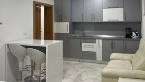 Un espacio habitable compacto con kitchenette, comedor y sofá.