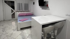 Un dormitorio con cama, escritorio y silla.