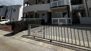 A multi-story residential building with balconies, a gated entrance, and a clear sky. - Apartment Lavaran 6 in Vir (Vir)