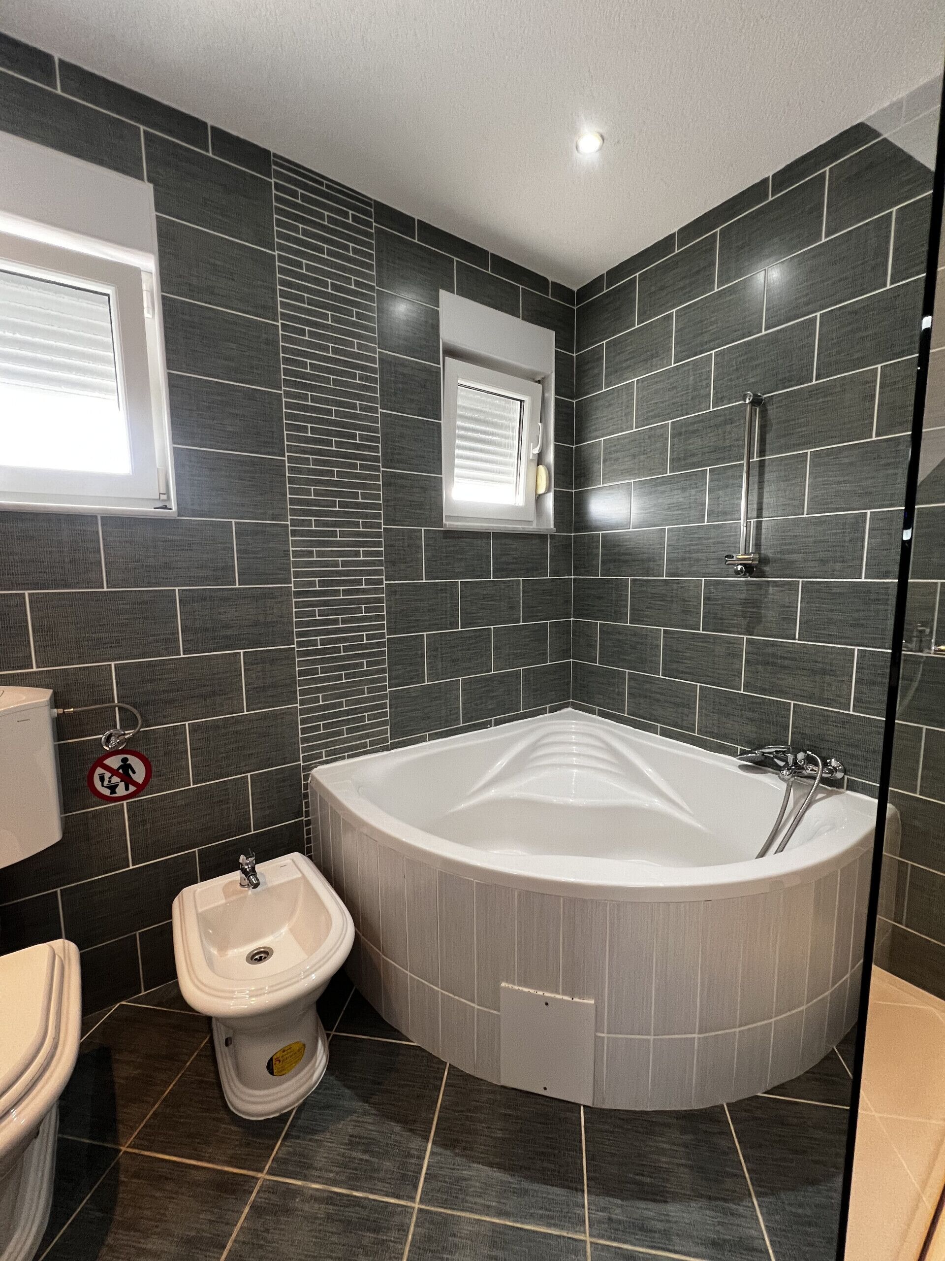 A modern bathroom with a freestanding bathtub, a bidet, and a toilet.