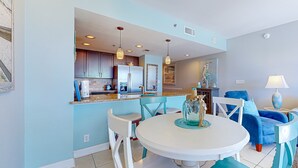 A modern kitchen with white cabinets, a central island, and pendant lighting.
