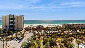 Een kusthotel met meerdere gebouwen, een parkeerplaats en uitzicht op het strand.