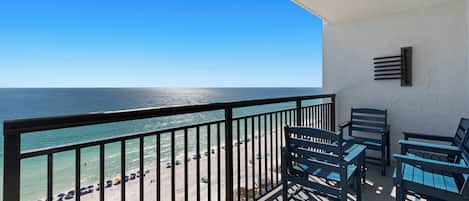 A balcony with a view of the beach and ocean.