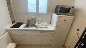 A compact kitchen with a sink, a microwave, and a refrigerator. - Lovely Apartment in Montmartre Paris - Fast Wifi (Paris)