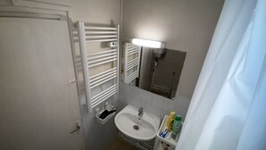 A small bathroom with a white sink, a mirror, and a towel rack. - Lovely Apartment in Montmartre Paris - Fast Wifi (Paris)