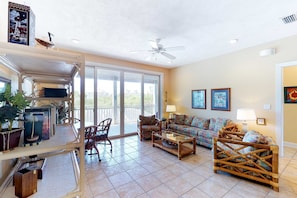 A spacious living room with a sofa, chairs, a coffee table, and a ceiling fan. - Dog-friendly home near the beach with private pool & gym (St. George Island)