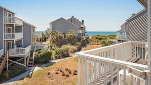 A coastal residential area with multiple two-story houses, a visible pathway, and a clear view of the ocean. - Dog-friendly townhome in private community with pool - near beach (Cape San Blas)