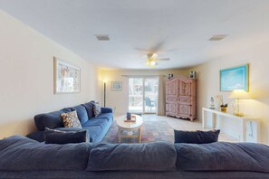 A living room with a sofa, a coffee table, and a cabinet. - Dog-friendly townhome in private community with pool - near beach (Cape San Blas)