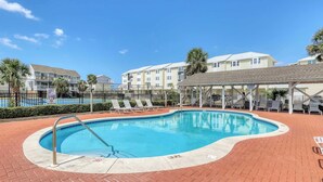 A swimming pool with a metal ladder, surrounded by a brick patio. - Dog-friendly townhome in private community with pool - near beach (Cape San Blas)