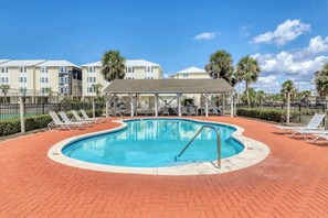 A swimming pool with lounge chairs, a covered seating area, and a brick patio. - Dog-friendly townhome in private community with pool - near beach (Cape San Blas)