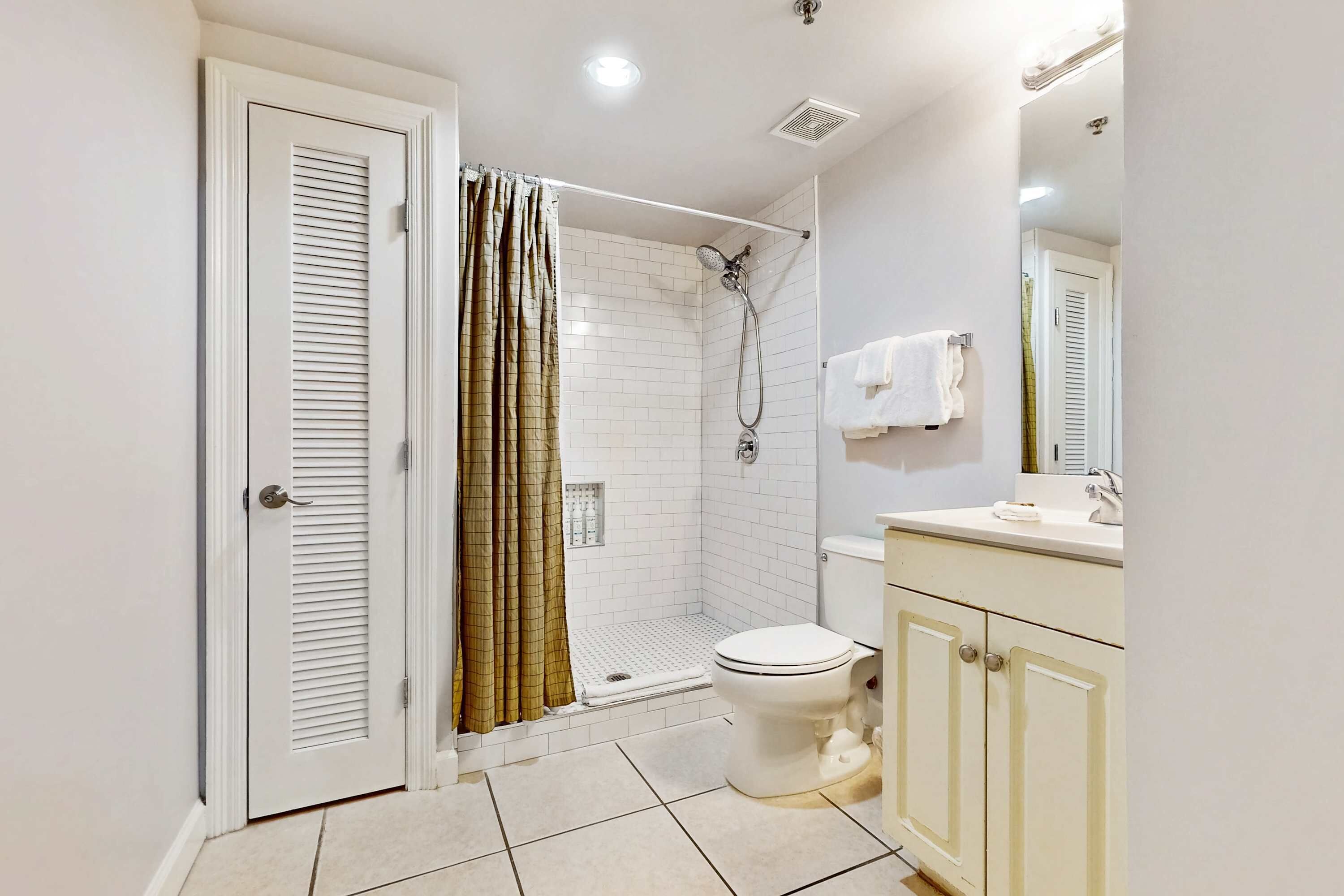 A bathroom with a shower, toilet, and sink.