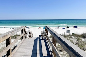 A wooden boardwalk leading to a sandy beach with clear blue water. - Pool-side condo with pool, private washer&dryer, walk to beach & free WiFi (Navarre Beach)