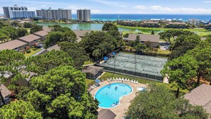 A residential area with a swimming pool, tennis courts, and a view of the ocean. - Sunny condo with lake views, outdoor pool, fast WiFi, tennis & central AC (Miramar Beach)