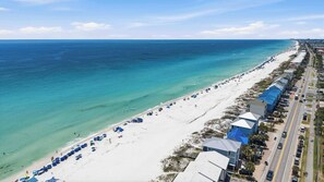 A coastal hotel with beach access, a road parallel to the beach, and a clear view of the ocean. - Sunny condo with lake views, outdoor pool, fast WiFi, tennis & central AC (Miramar Beach)