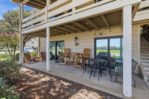 A covered outdoor seating area with chairs and tables, a pergola, and a view of a residential neighborhood. - Sunny condo with lake views, outdoor pool, fast WiFi, tennis & central AC (Miramar Beach)
