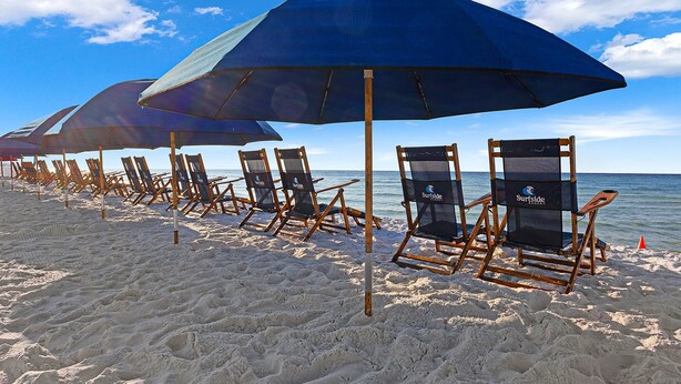 A row of beach chairs with umbrellas on a sandy beach. - Gorgeous ground-floor condo, private patio,  shared pool and beach access (Miramar Beach)