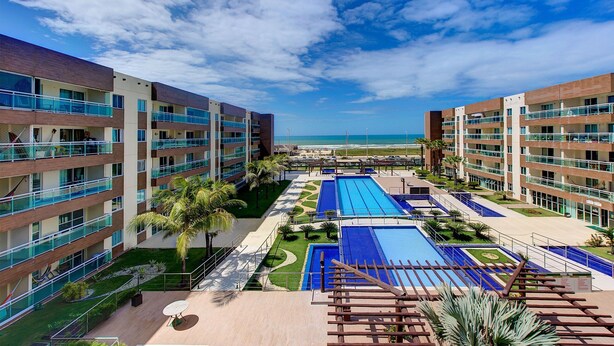 Un hotel con varias plantas, piscina y vista al océano.