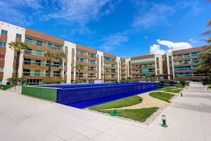 A modern hotel with multiple floors, outdoor swimming pool, and well-maintained landscaping. - VG Fun #405 - Praia do Futuro by Carpediem (Fortaleza)