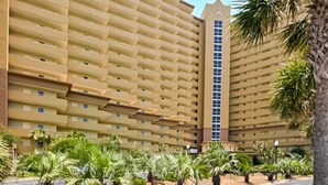 A large, multi-story hotel with a uniform facade and a central vertical tower. - Gulf-view condo at beachfront resort with pools, hot tub & 2 gyms (Destin)