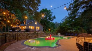 A backyard with a swimming pool, inflatable flamingo, and a house with outdoor seating. - Welcome to the secluded waterfront oasis (Millington)