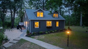 A two-story house with a covered porch, a well-maintained lawn, and a pathway leading to the entrance. - Welcome to the secluded waterfront oasis (Millington)