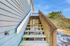A wooden staircase leading up to a house with a white exterior. - Gorgeous private home with gulf views, dog-friendly & community pool (St. George Island)