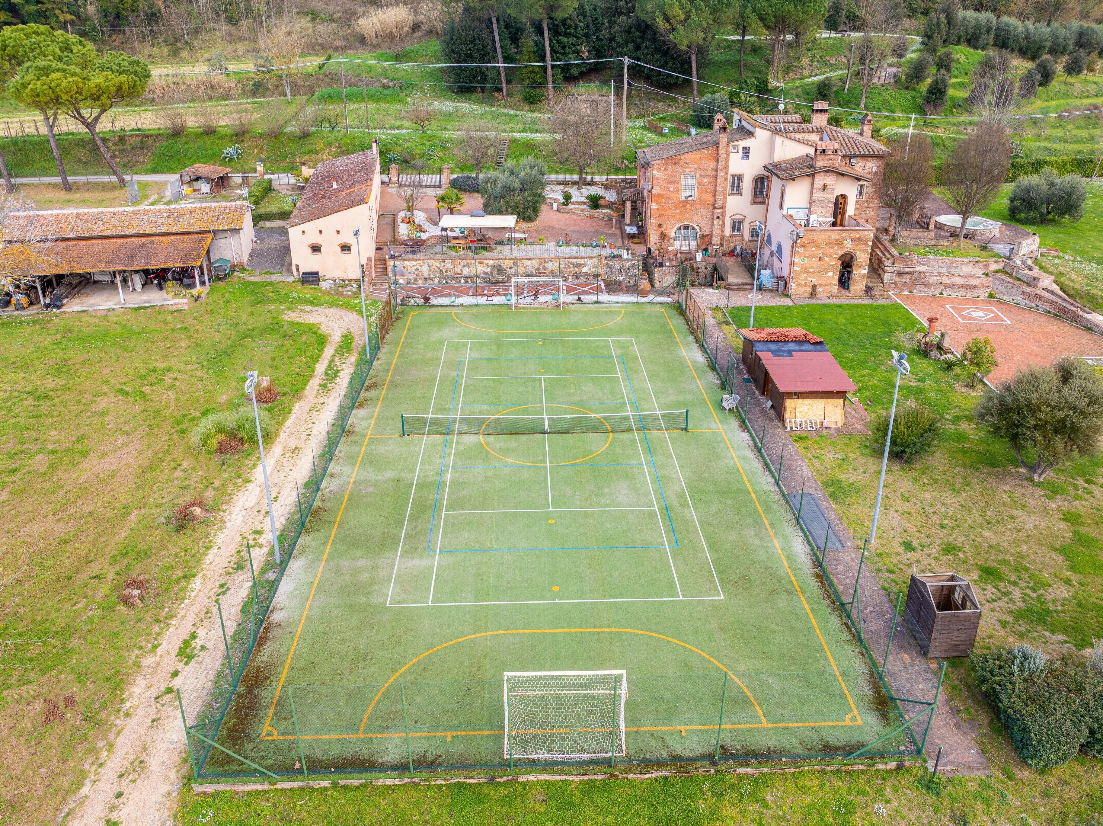 An aerial view of a sports court surrounded by buildings, with a clear boundary line and goalpost.