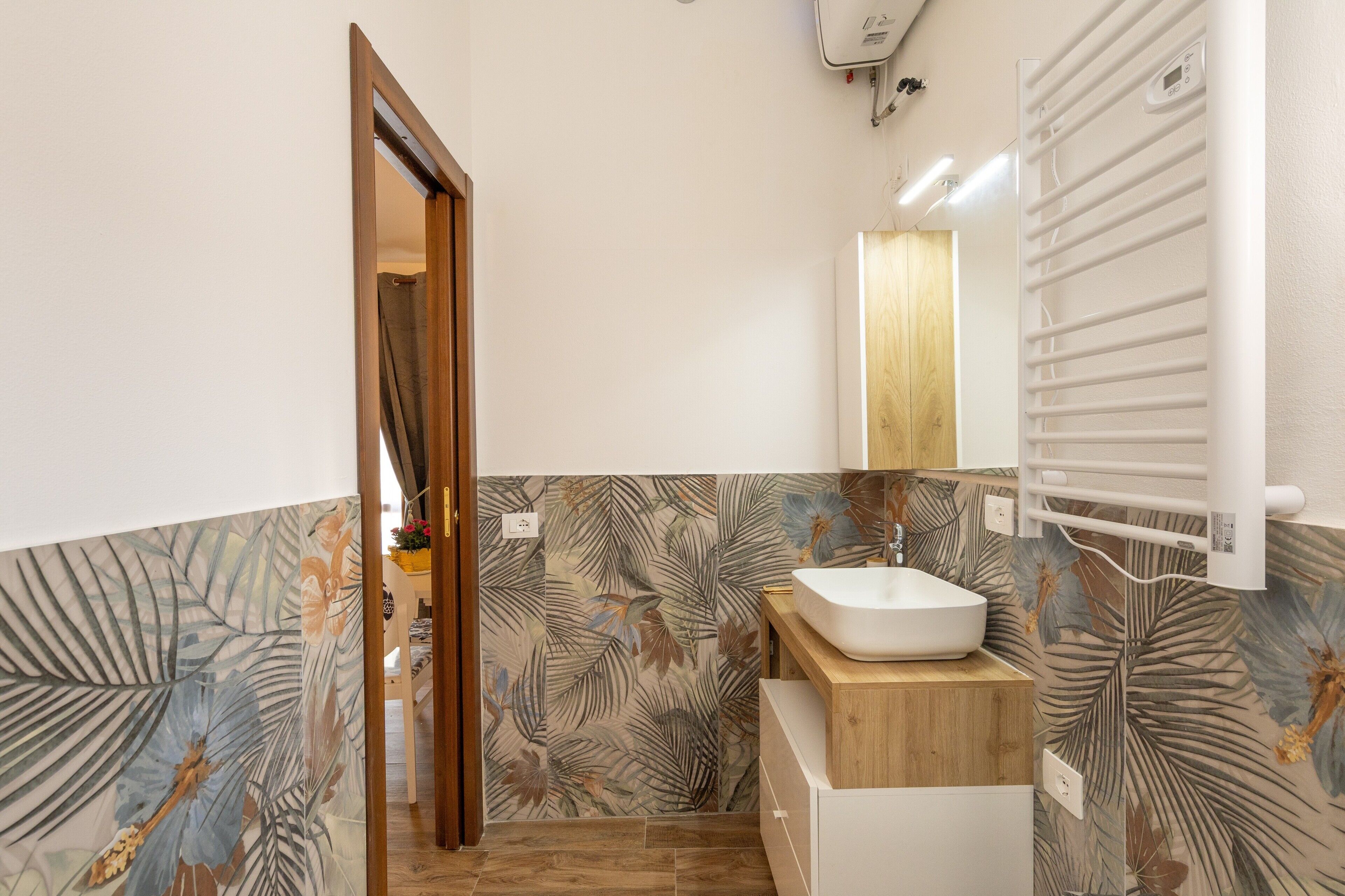 Une salle de bain avec un meuble-lavabo en bois, un lavabo blanc et un porte-serviettes.