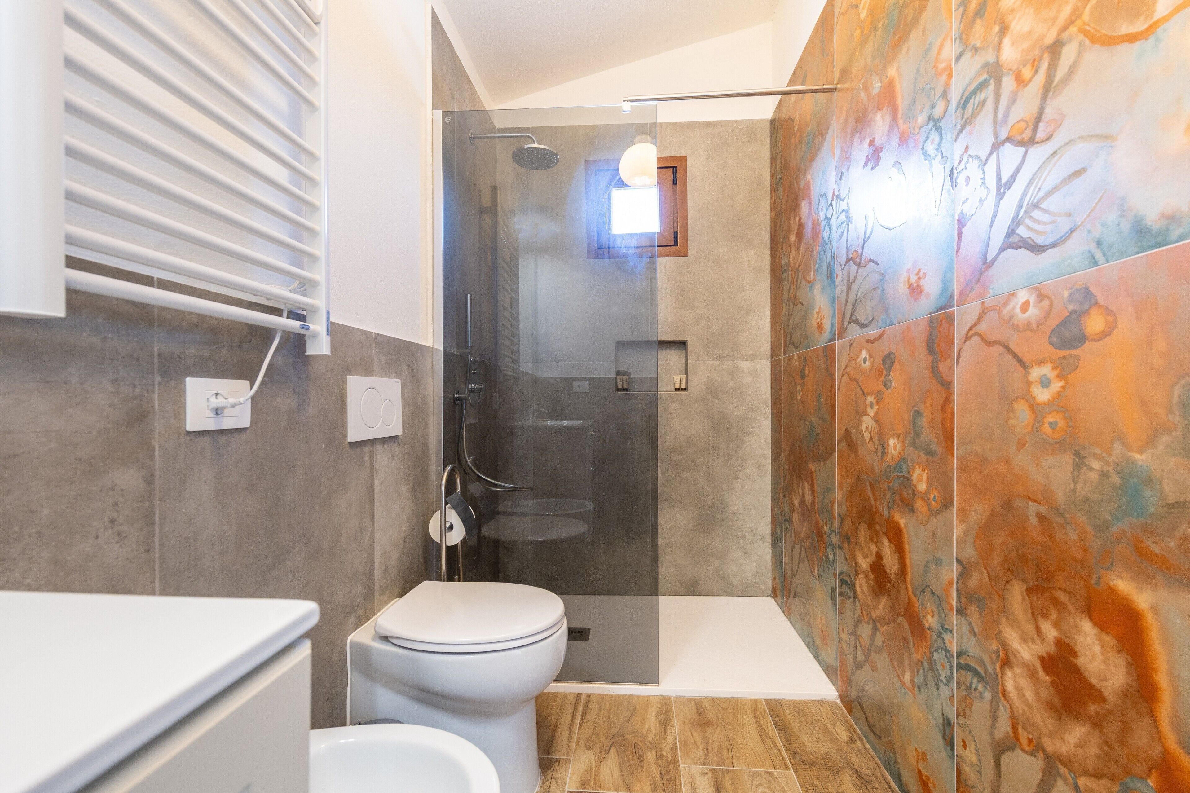 Un baño moderno con ducha de vidrio, inodoro y lavabo.