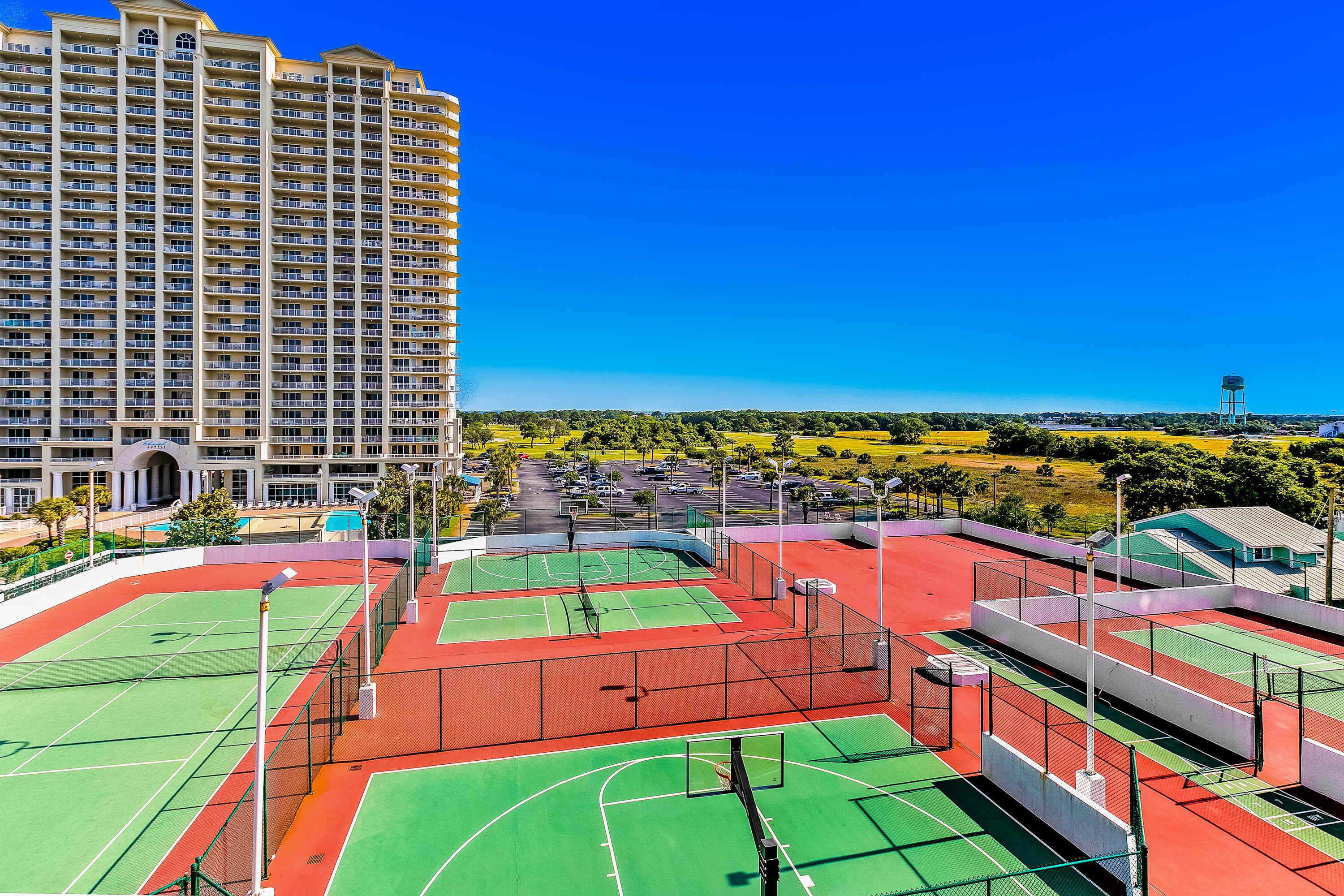 A multi-story hotel with a tennis court complex.