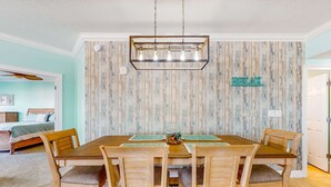Un'area pranzo con un tavolo e sedie in legno, un lampadario e un cartello con la scritta 'RELAX'.