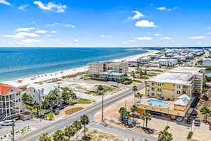 A coastal hotel with multiple buildings, a beach, and a road. - Fourth Floor Condo with Shared Pool, Ocean View, High-Speed WiFi, & Washer/Dryer (Mexico Beach)