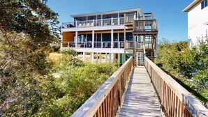 A multi-story building with a wooden deck leading to a balcony. - Dog-friendly oceanfront home with a hot tub, washer&dryer & central AC (Cape San Blas)