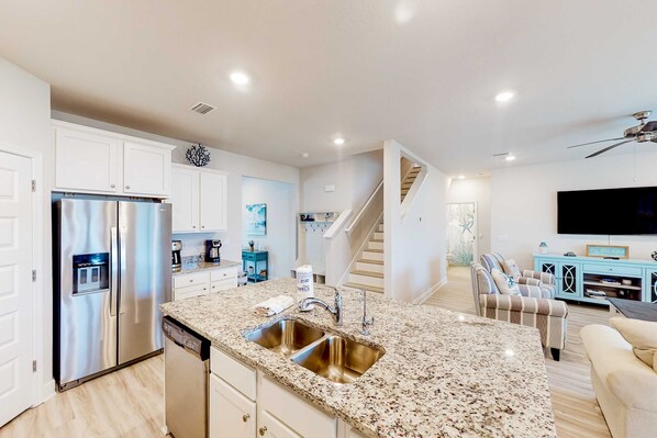 A modern kitchen with stainless steel appliances, a granite countertop, and a built-in dishwasher. - Brand-new beach house with pool, beach access, AC, & W/D, Snowbirds welcome! (Port St. Joe)