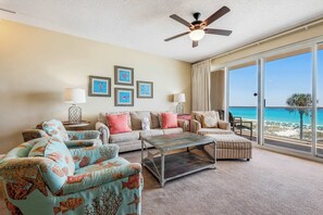 A spacious living room with a large window offering a view of the beach. - Stunning, waterfront home with Gulf views, pool & fitness room access (Destin)