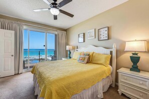 A bedroom with a bed, a ceiling fan, a nightstand, and a view of the ocean. - Stunning, waterfront home with Gulf views, pool & fitness room access (Destin)