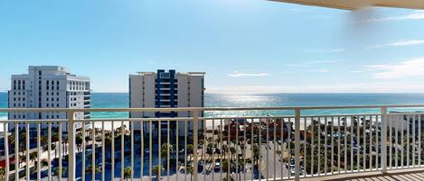 A balcony with a view of the ocean and buildings.