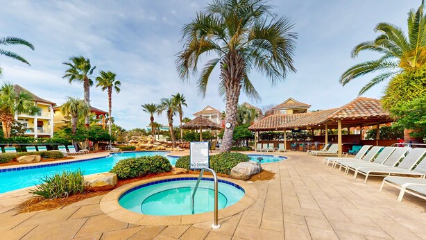 A pool area with lounge chairs, palm trees, and a 'NO DIVING' sign. - Snowbird-friendly home in gated community with hot tub, pool, balcony, & grill (Destin)