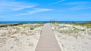 A wooden boardwalk leading to a beach with a clear blue sky. - Scenic waterfront home with five bedrooms & easy beach access - dog-friendly (St. George Island)