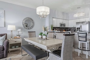 A modern kitchen with white cabinets, a microwave, and a stainless steel refrigerator. - Beach-view penthouse condo with stunning water views, on-site pool & hot tub (Destin)