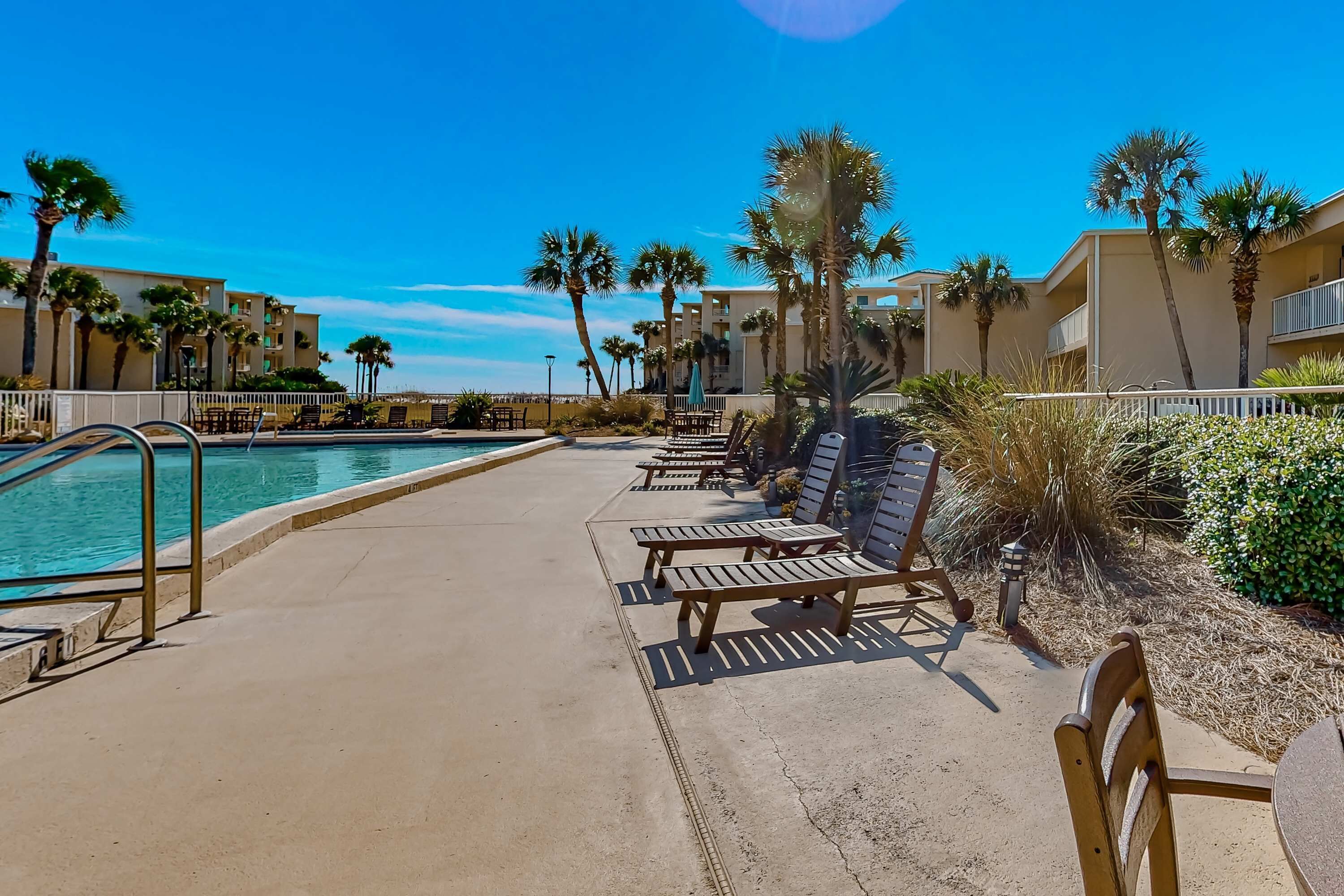 A poolside area with lounge chairs and a swimming pool.