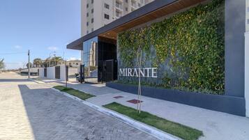 A modern building with a sign reading "MIRANTE" and a green wall with climbing plants.