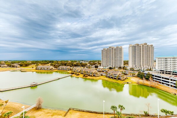 A resort area with a large body of water, multiple high-rise buildings, and a dock. - Majestic Sun B1010 Beachfront Bliss with Pool! (Miramar Beach)
