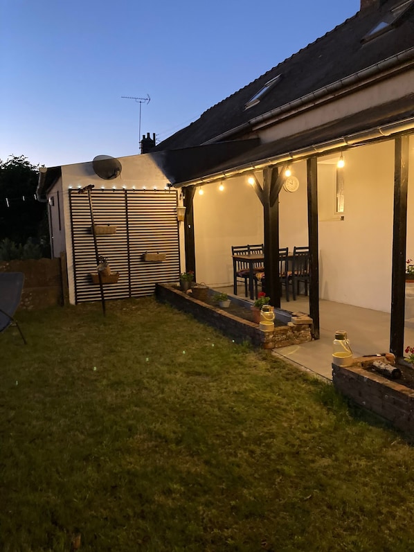 Une maison dotée d’un patio couvert, d’une pelouse et d’une antenne parabolique.