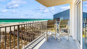 Ein Balkon mit Blick auf Strand und Meer.